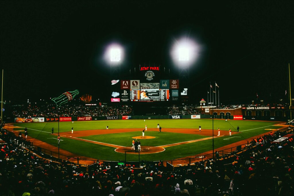Exciting evening baseball game with fans at AT&T Park stadium under bright lights.