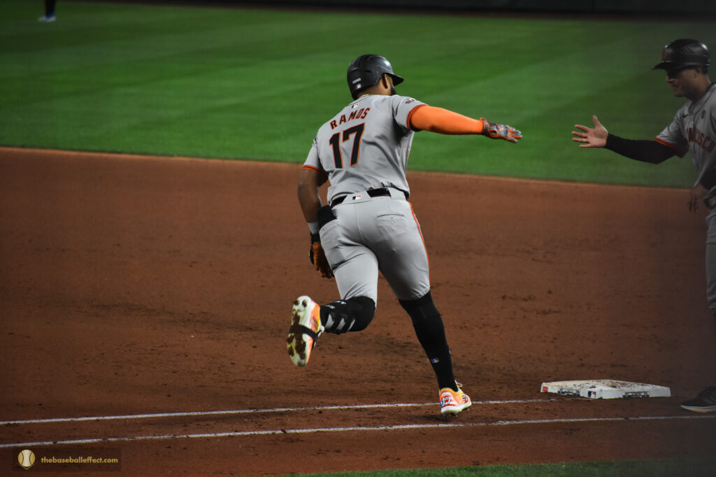 Heliot Ramos high-fives the first base coach in celebration after a homerun, T-Mobile Park 2024