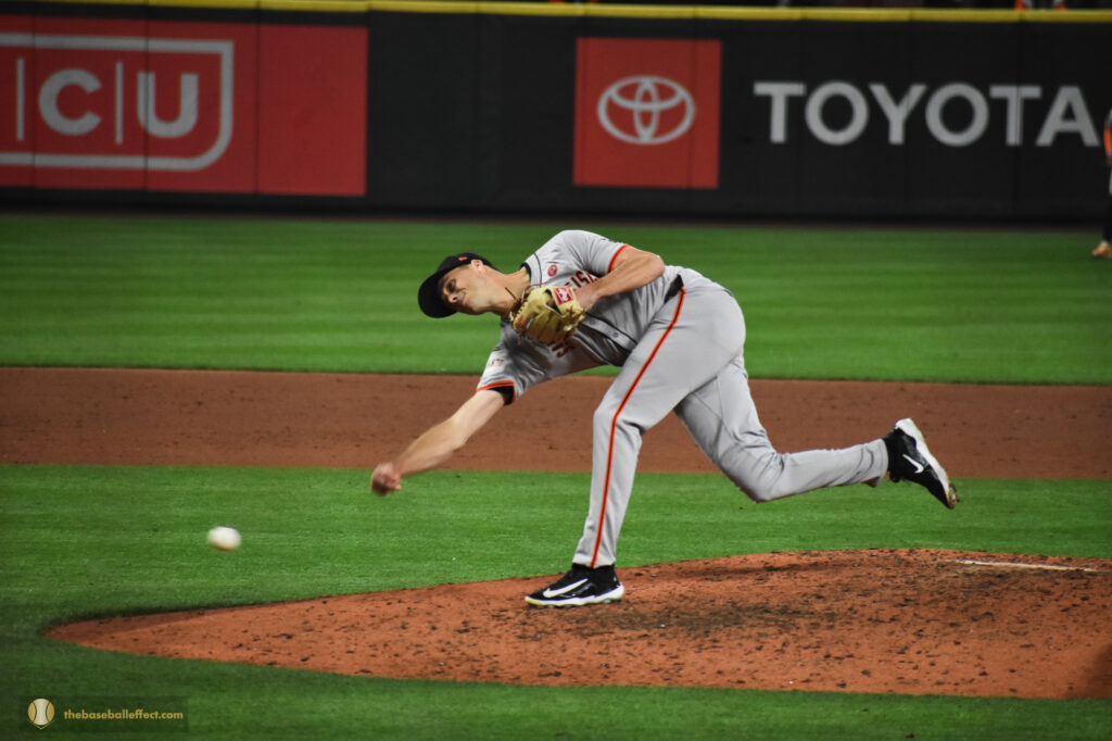 Tyler Rogers almost scrapes the ground with his hand as he throws toward homeplate, Giants - Mariners, T-Mobile Park 2024